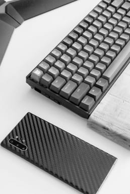 A keyboard with an orange overlay next to a phone on a table